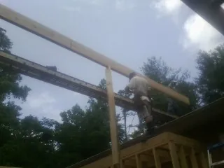 Carpenter setting a ridge beam over a new addition frame — Ice Dam Removal by Roofing Brothers in Algonquin