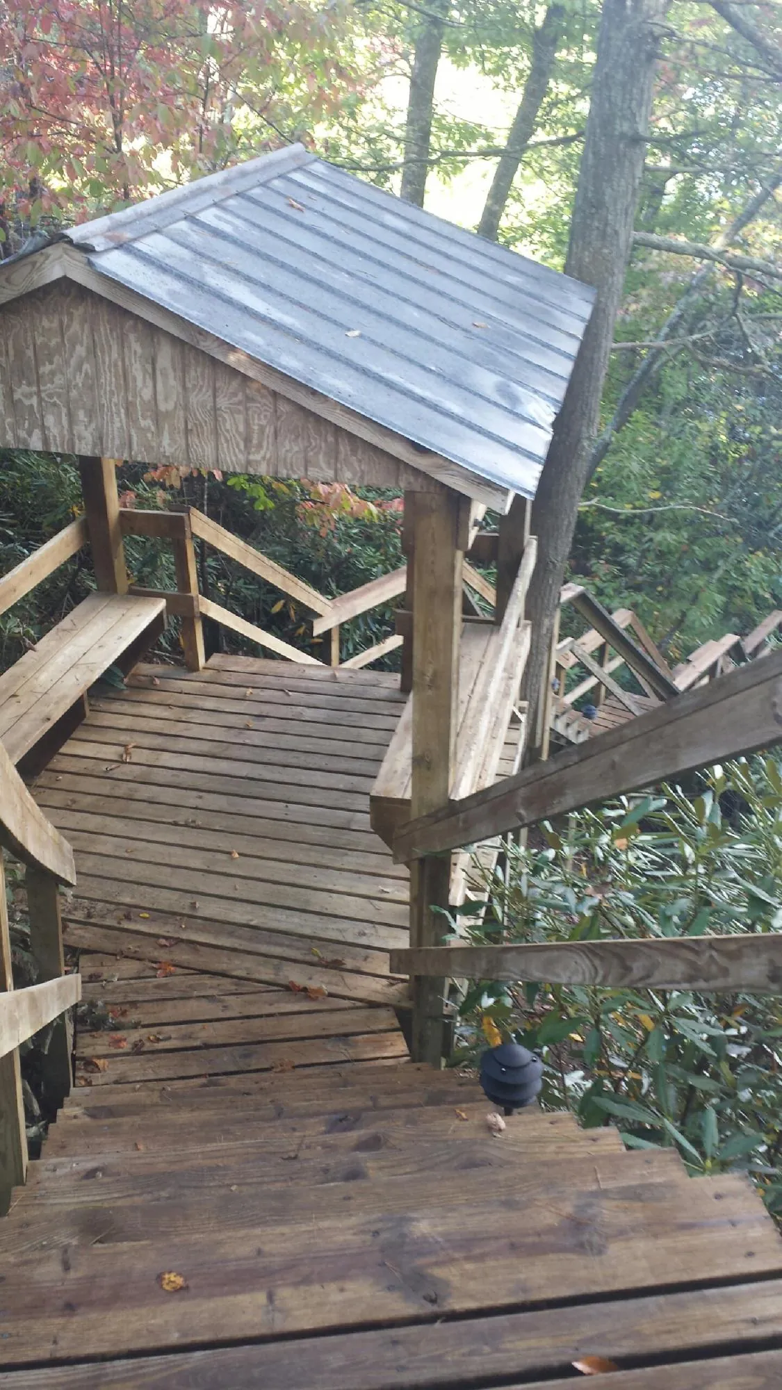 Metal roofed shelter over wooden steps on a wooded walkway — Skylight Repair & Installation work by our crew in Algonquin