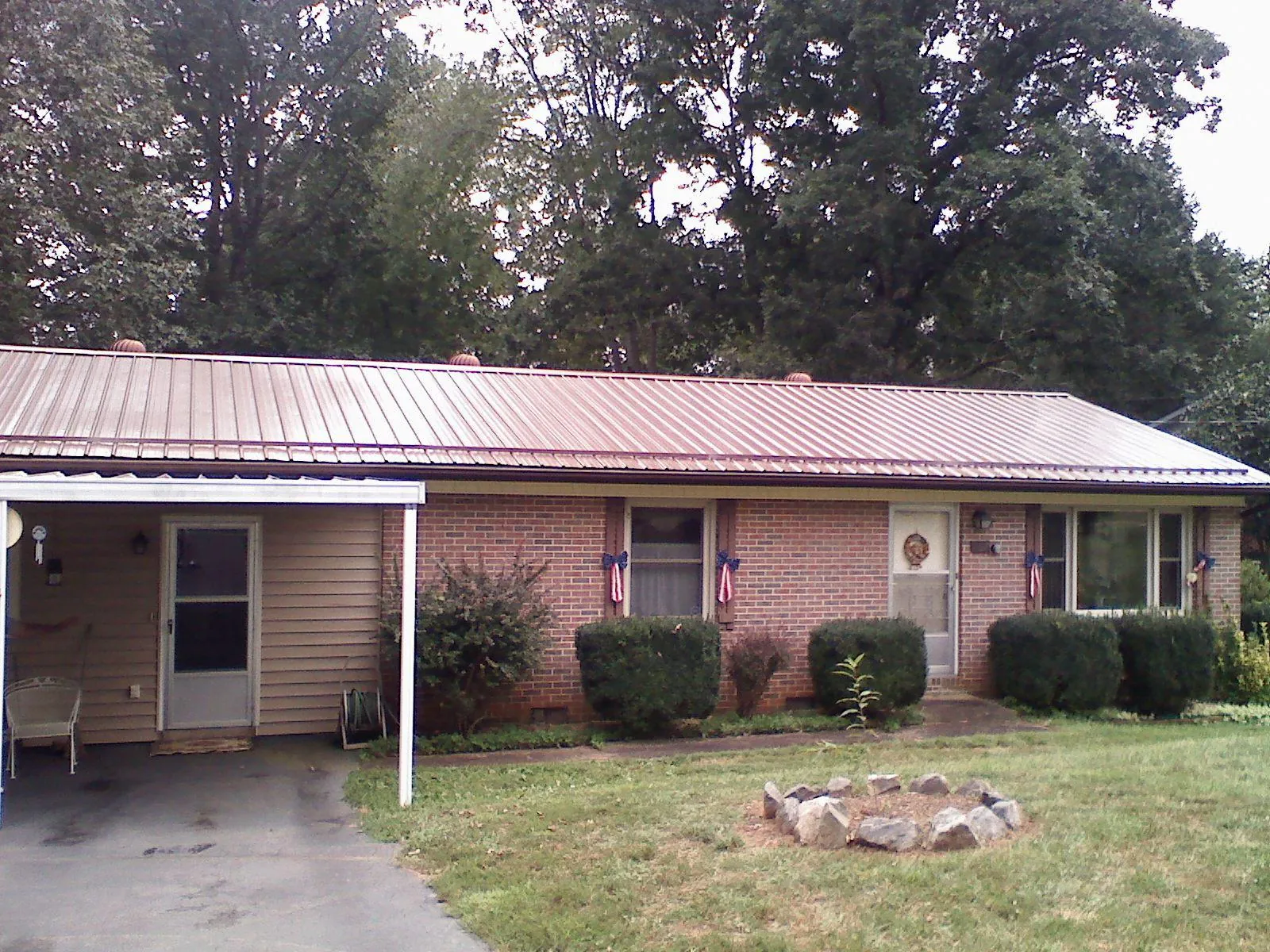 Bronze metal roof and carport on a brick ranch home — Roof Repair work by our crew in Algonquin